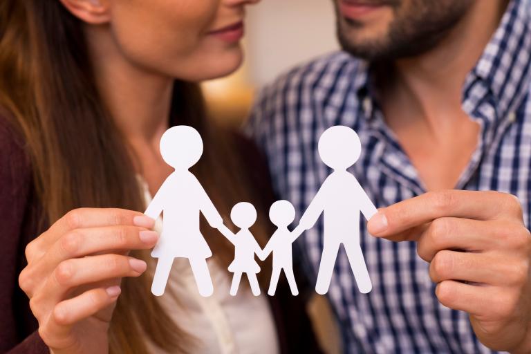 Couple holding a cut out of a family